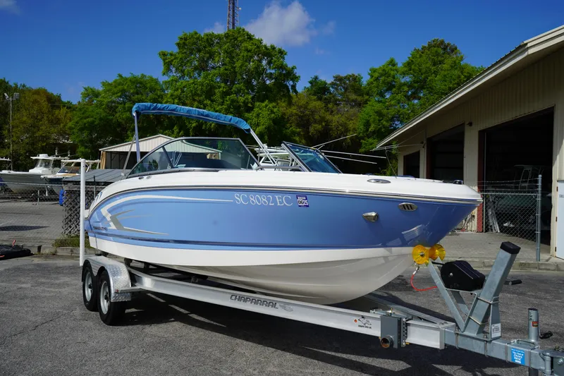 Slide: The Image of 2023 Chaparral 21 SSi OB boat on trailer, parked outdoors near a building. - 3