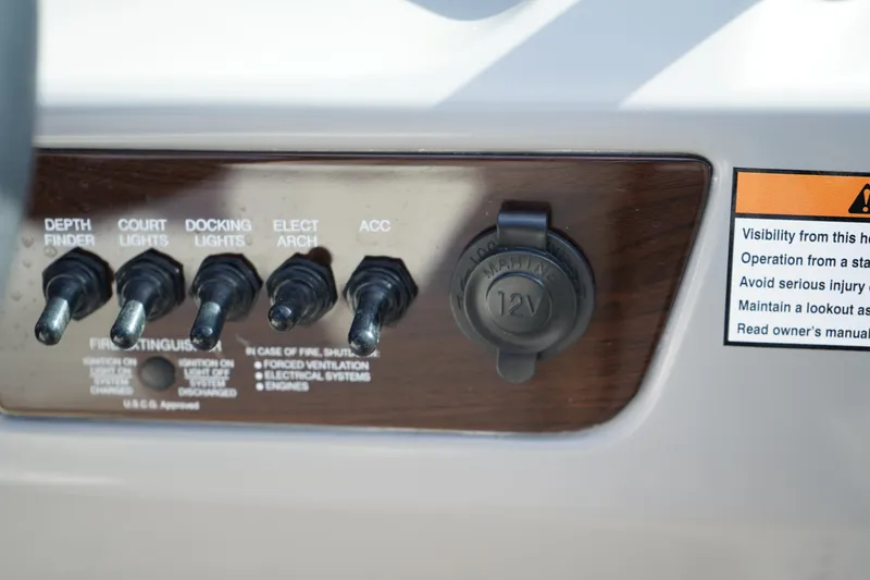 Slide: The Image of Control panel of 2023 Chaparral 21 SSi OB boat with switches and 12V outlet. - 31
