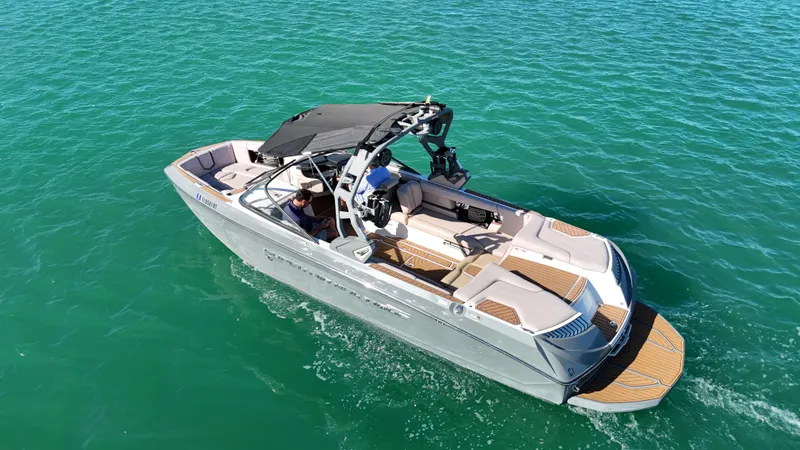 Slide: The Image of 2018 Nautique Super Air Nautique G25 boat cruising on clear turquoise water. - 2
