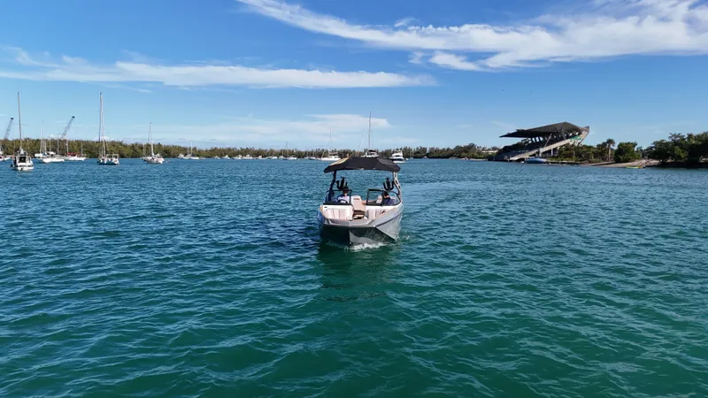 Slide: The Image of 2018 Nautique Super Air Nautique G25 on calm blue water, clear sky background. - 22