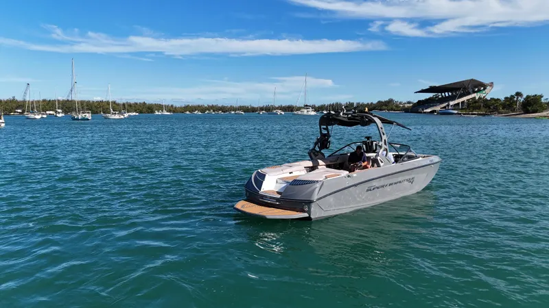 Slide: The Image of 2018 Nautique Super Air Nautique G25 boat on calm blue water, clear sky background. - 26