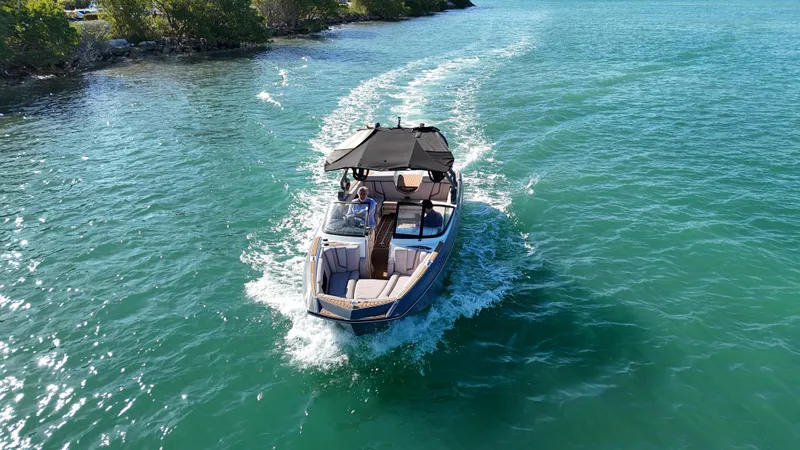 Slide: The Image of 2018 Nautique Super Air Nautique G25 cruising on clear blue water. - 28