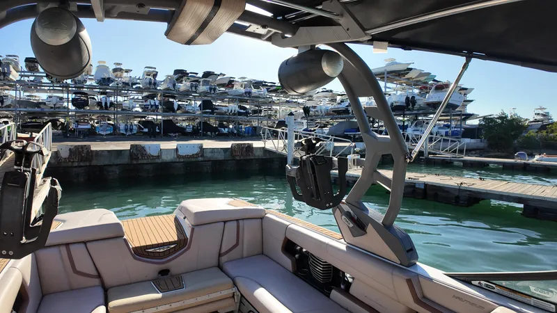 Slide: The Image of Interior view of 2018 Nautique Super Air Nautique G25 boat docked at marina. - 31