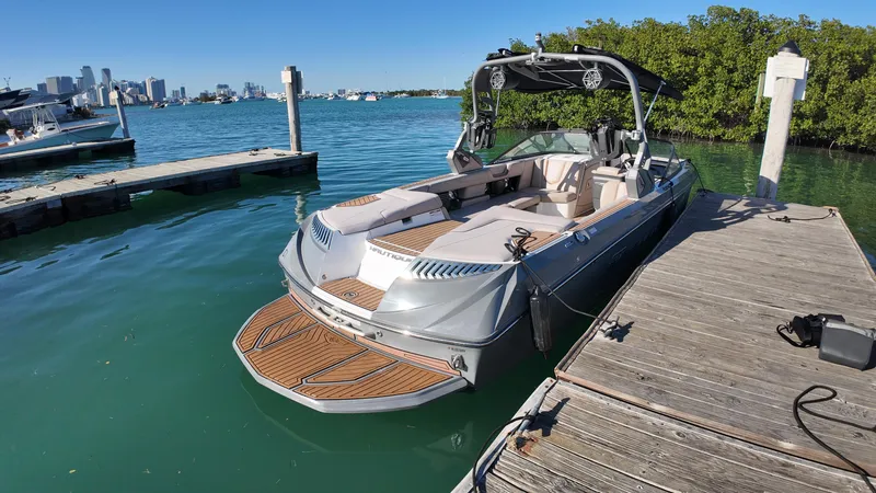 Slide: The Image of 2018 Nautique Super Air Nautique G25 boat docked on clear blue water. - 34