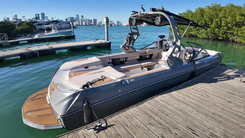 Slide: The Image of 2018 Nautique Super Air Nautique G25 boat docked by the water with city skyline. - 35