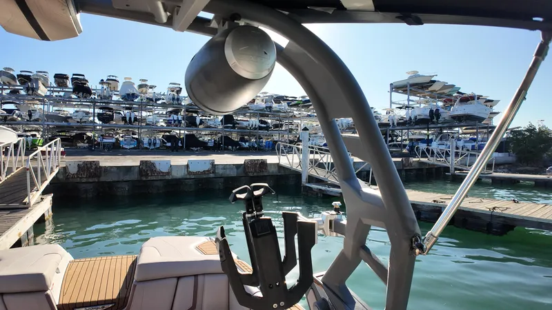 Slide: The Image of 2018 Nautique Super Air Nautique G25 boat docked, with marina and stacked boats in background. - 42