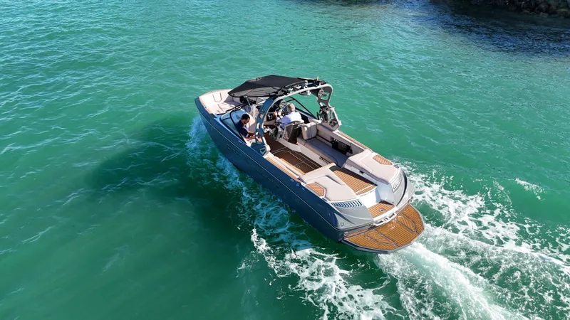 Slide: The Image of 2018 Nautique Super Air Nautique G25 cruising on clear turquoise water. - 8