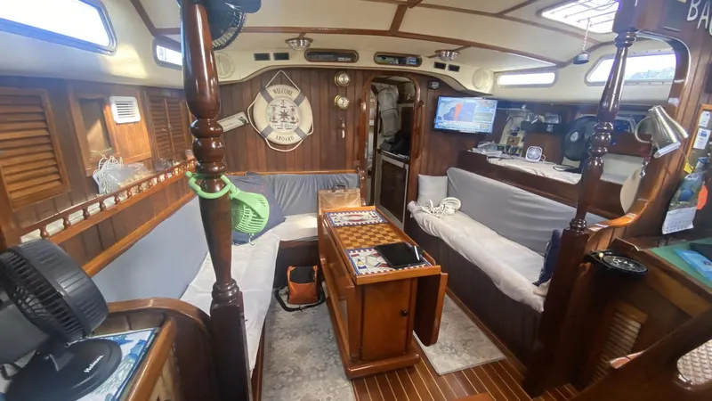 Slide: The Image of Interior of 1990 Bruce Roberts 43 Mauritius sailboat with wood finish and cozy seating area. - 11