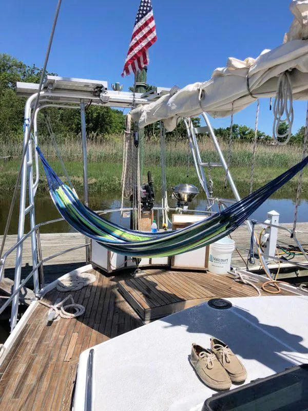 Slide: The Image of Sailboat deck with hammock, shoes, and American flag; Bruce Roberts 43 Mauritius, 1990 model. - 12