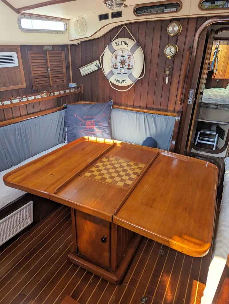Slide: The Image of Cozy interior of 1990 Bruce Roberts 43 Mauritius sailboat with wooden table and nautical decor. - 23