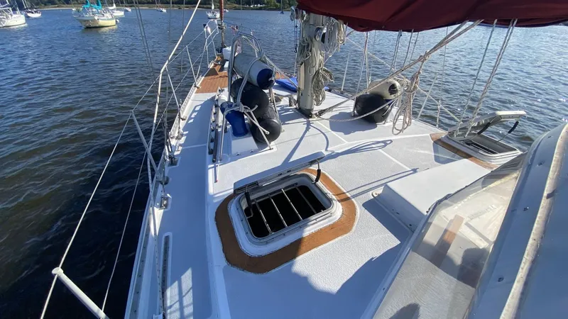 Slide: The Image of Sailboat deck of 1990 Bruce Roberts 43 Mauritius on water, featuring open hatches and rigging. - 25