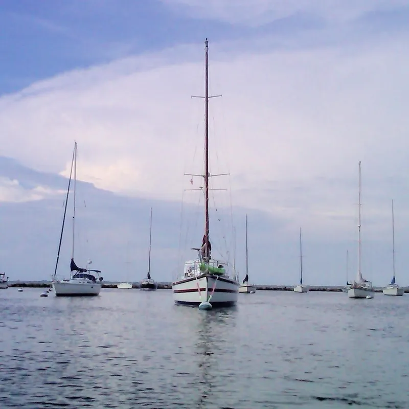 Slide: The Image of Sailboats anchored in calm waters, featuring a 1990 Bruce Roberts 43 Mauritius. - 4