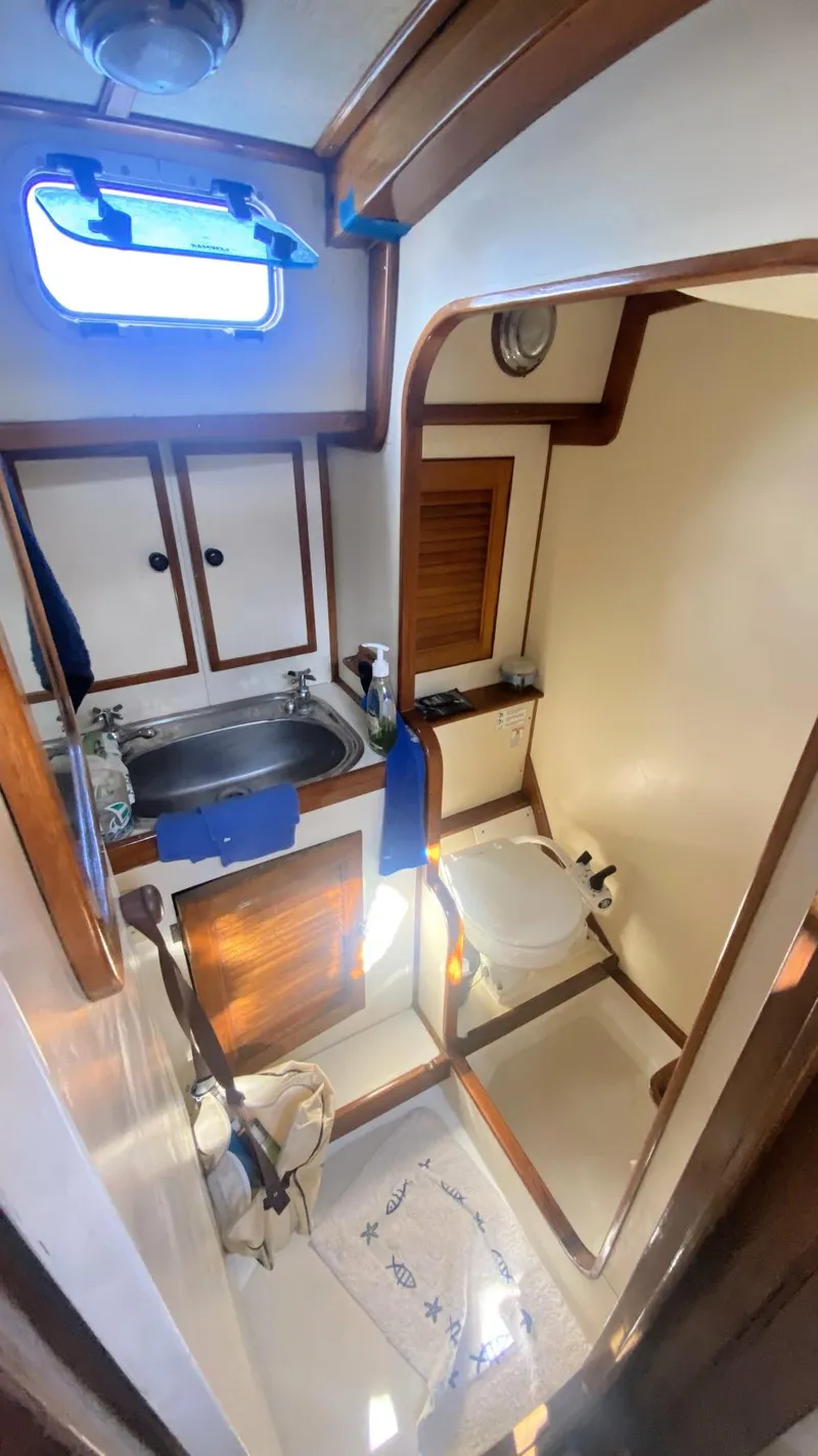 Slide: The Image of 1990 Bruce Roberts 43 Mauritius yacht bathroom with sink, storage, and porthole window. - 5