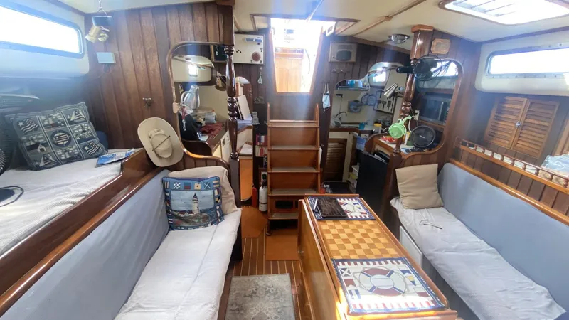 Slide: The Image of Interior of 1990 Bruce Roberts 43 Mauritius sailboat with cozy seating and wooden accents. - 9