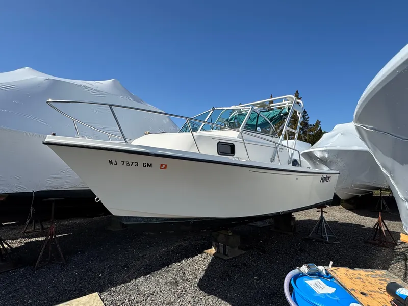 Slide: The Image of 2000 Parker 2110 Walkaround boat on stands, surrounded by covered vessels. - 1