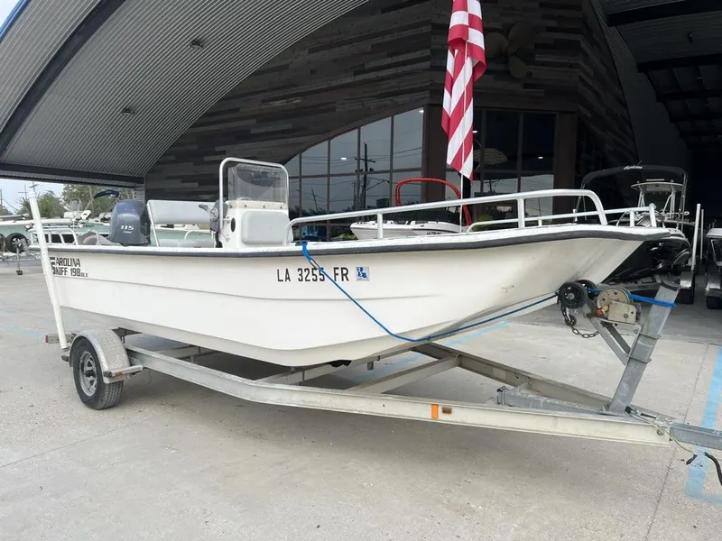 Slide: The Image of 2007 Carolina Skiff 198 DLX boat on trailer, parked outside a building. - 11