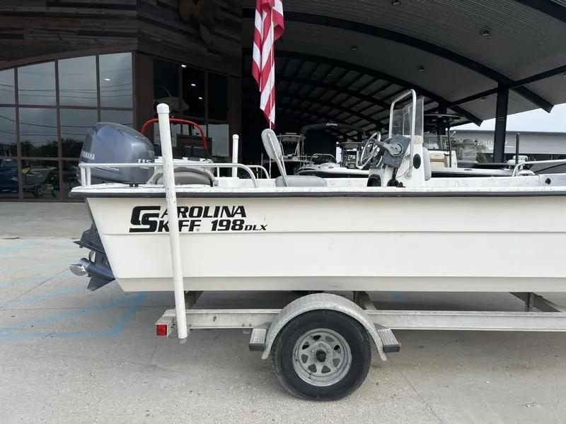 Slide: The Image of 2007 Carolina Skiff 198 DLX boat on trailer, parked outside a building. - 8