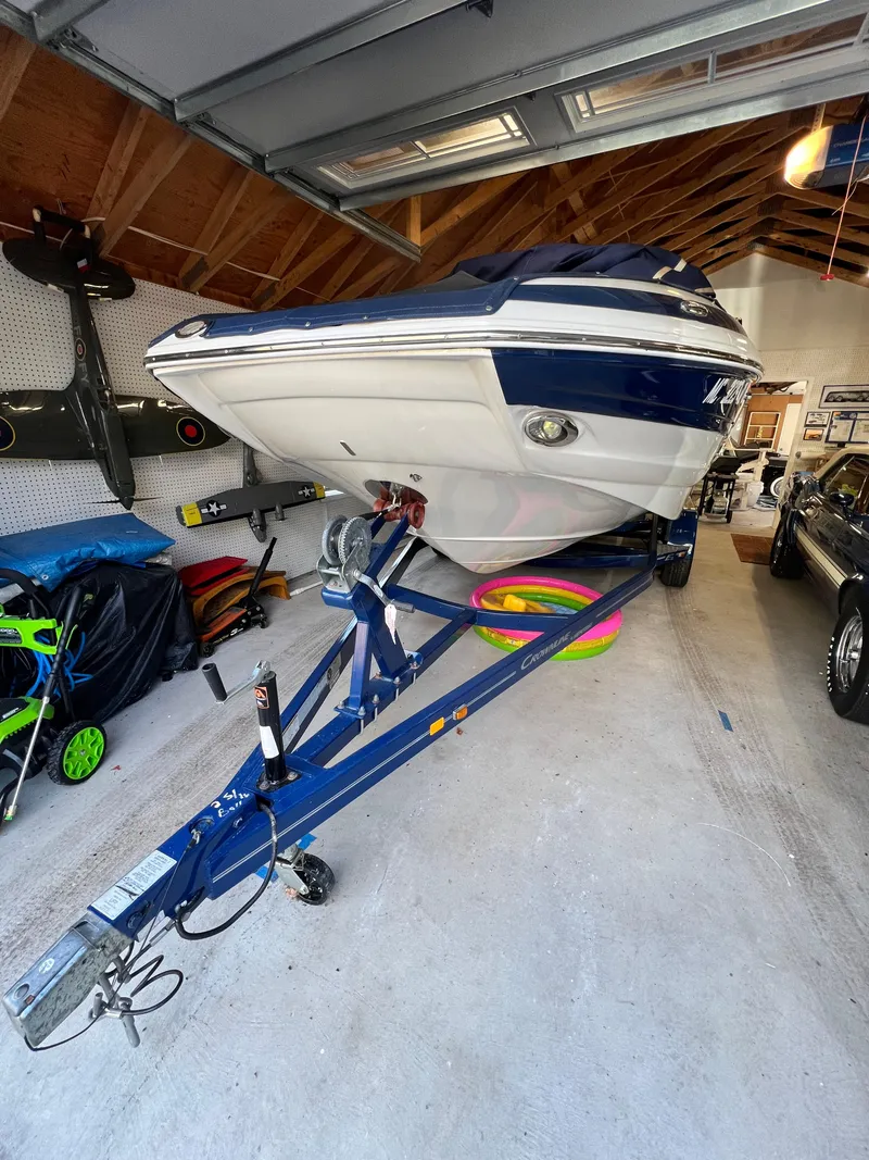 Slide: The Image of 2012 Crownline E2 Eclipse boat on trailer in a garage setting. - 1