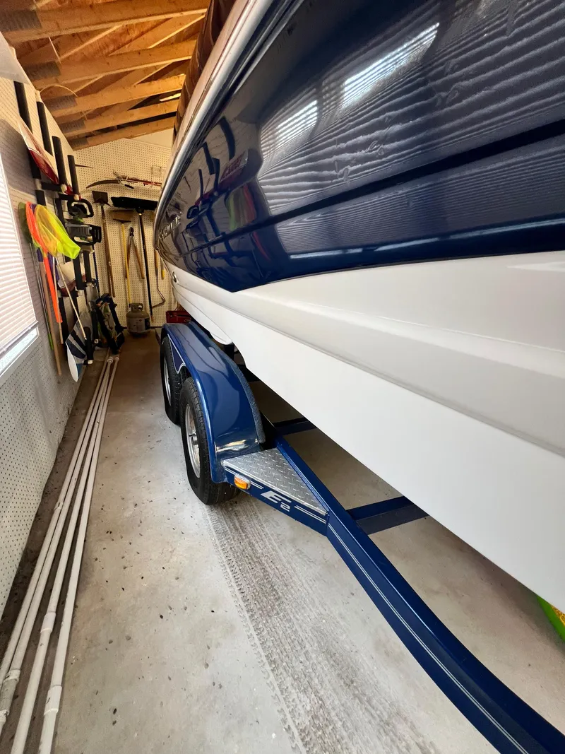 Slide: The Image of 2012 Crownline E2 Eclipse boat on trailer in garage. - 3