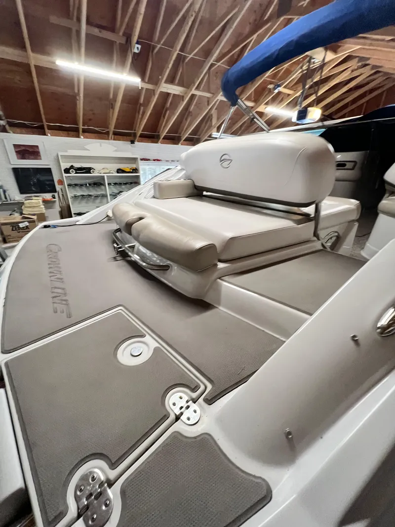 Slide: The Image of 2012 Crownline E2 Eclipse boat interior with cushioned seating in a wooden garage. - 7