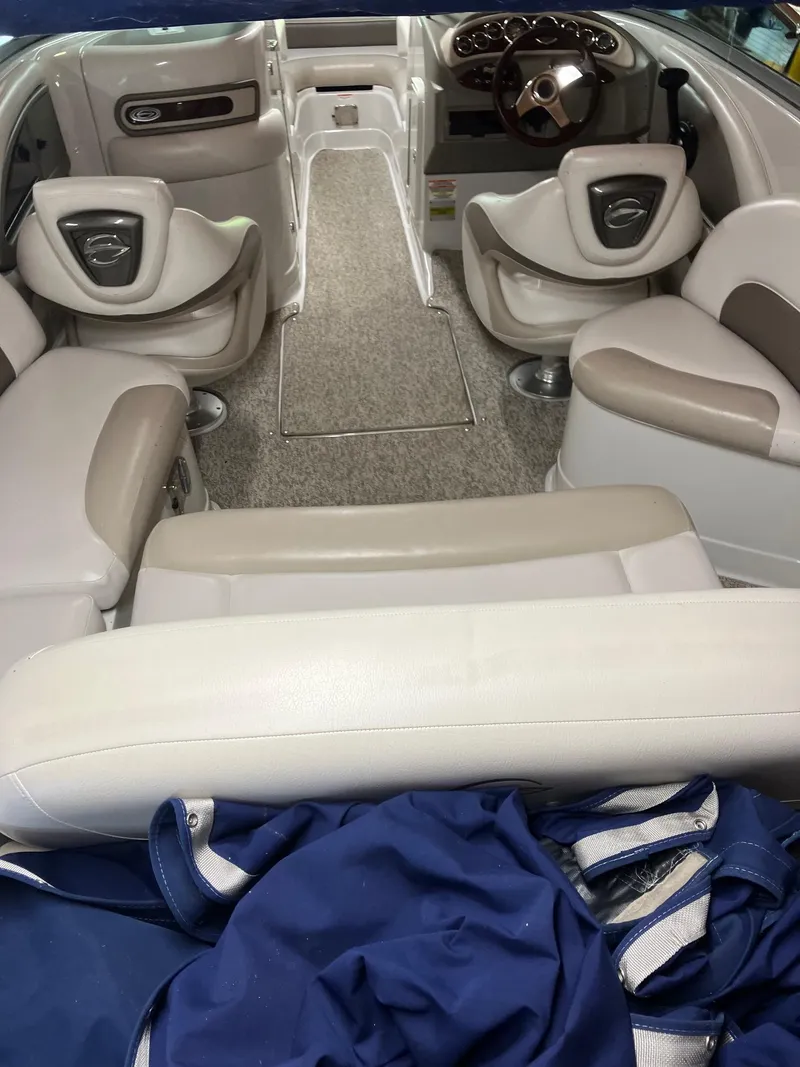 Slide: The Image of Interior of a 2012 Crownline E2 Eclipse boat with beige seating and steering wheel. - 8