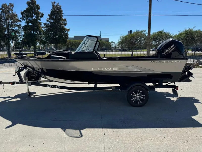 Slide: The Image of 2022 Lowe Fishing Machine 1675 WT boat on trailer, side view, outdoors. - 1