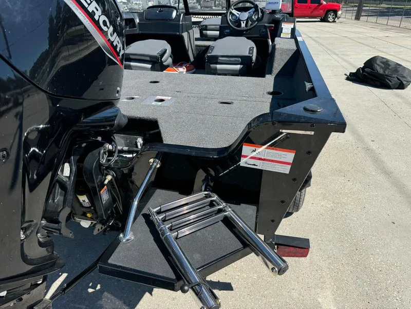 Slide: The Image of 2022 Lowe Fishing Machine 1675 WT with Mercury engine and foldable ladder on a sunny day. - 11