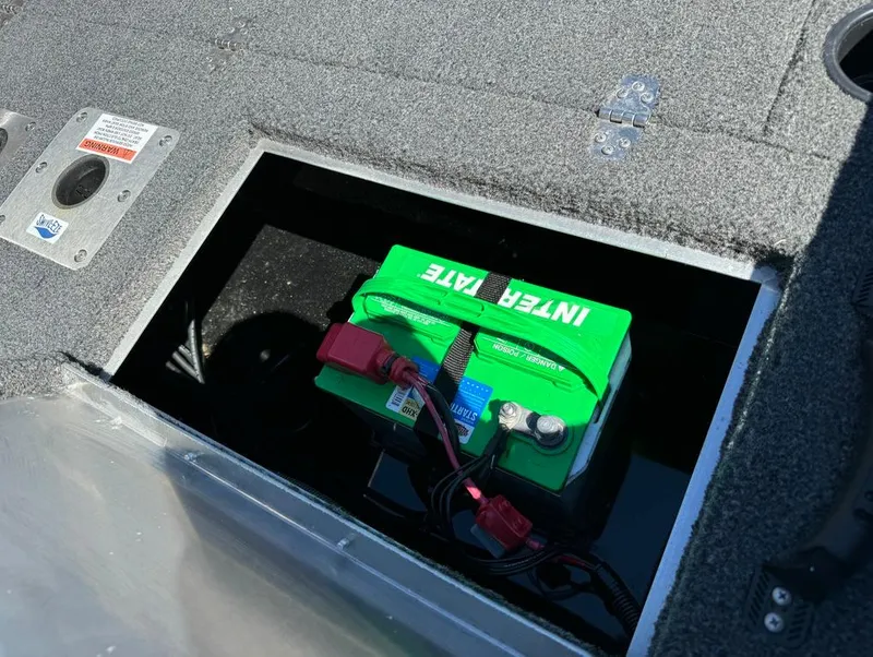 Slide: The Image of 2022 Lowe Fishing Machine 1675 WT battery compartment with green Interstate battery. - 12