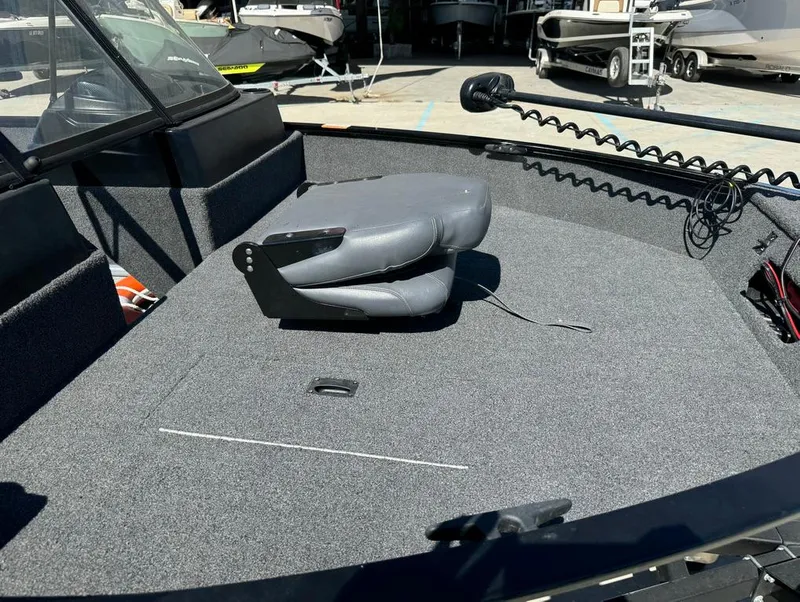 Slide: The Image of 2022 Lowe Fishing Machine 1675 WT boat interior with gray seating and carpeted deck. - 17