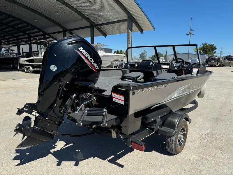 Slide: The Image of 2022 Lowe Fishing Machine 1675 WT with Mercury outboard motor, parked outdoors. - 6