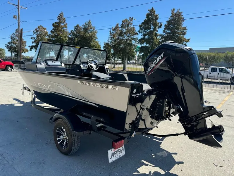Slide: The Image of 2022 Lowe Fishing Machine 1675 WT with Mercury outboard motor, parked outdoors. - 8