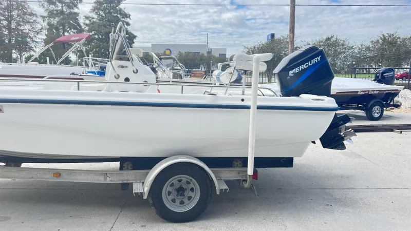 Slide: The Image of 2002 Fishmaster 1900 boat on trailer with Mercury outboard motor, parked outdoors. - 10