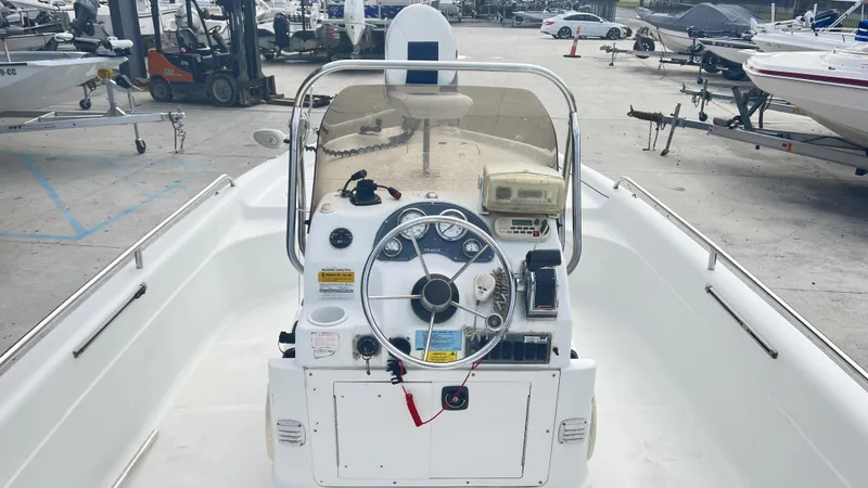 Slide: The Image of 2002 Fishmaster 1900 boat interior with steering wheel and control panel in a marina. - 11