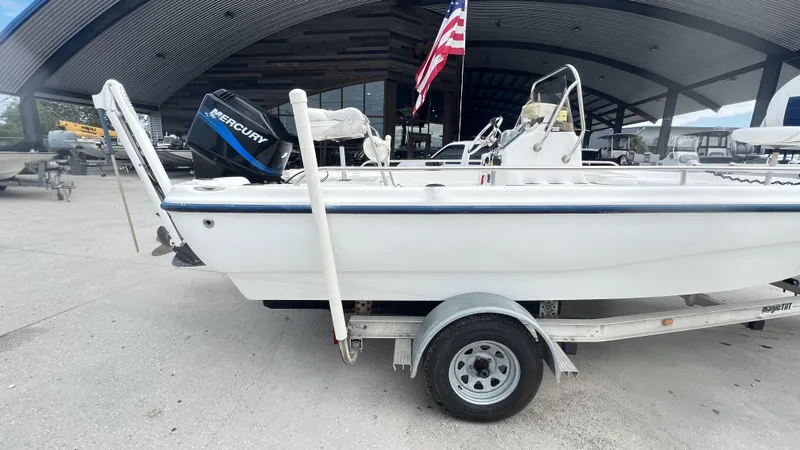 Slide: The Image of 2002 Fishmaster 1900 boat on trailer with Mercury outboard motor, parked outdoors. - 13