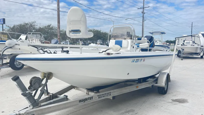 Slide: The Image of 2002 Fishmaster 1900 boat on trailer, parked outdoors under cloudy sky. - 4