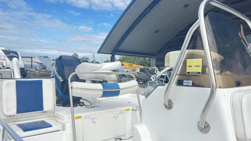 Slide: The Image of 2002 Fishmaster 1900 boat with Mercury engine, parked under a metal canopy. - 6