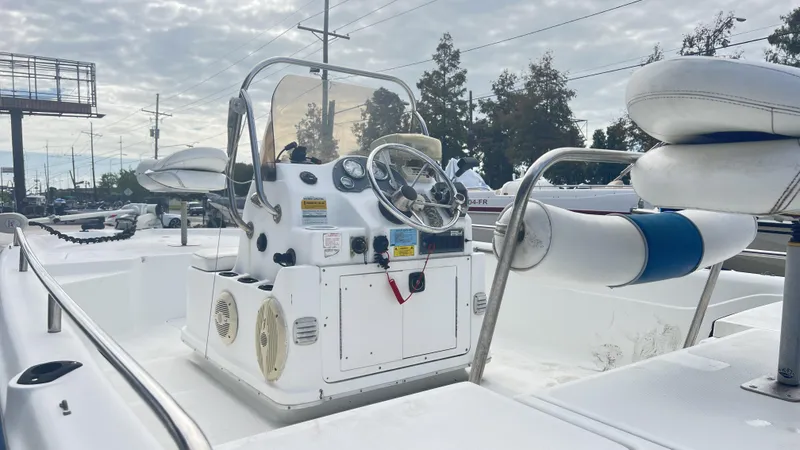 Slide: The Image of 2002 Fishmaster 1900 boat interior with steering console and seating, docked outdoors. - 7