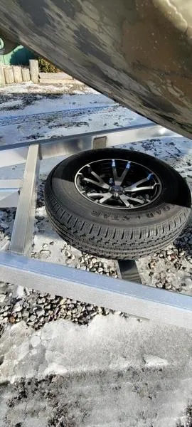 Slide: The Image of 2023 Thor Lake Hammer 1754 Elite trailer with spare tire on icy ground. - 4