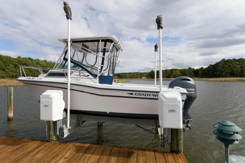 Slide: The Image of 1994 Grady-White Adventure 208 boat docked on a lift by a serene lake. - 0