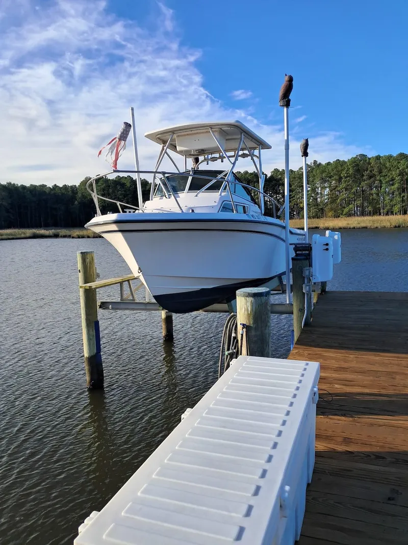 Slide: The Image of 1994 Grady-White Adventure 208 boat docked on a sunny day by the water. - 1