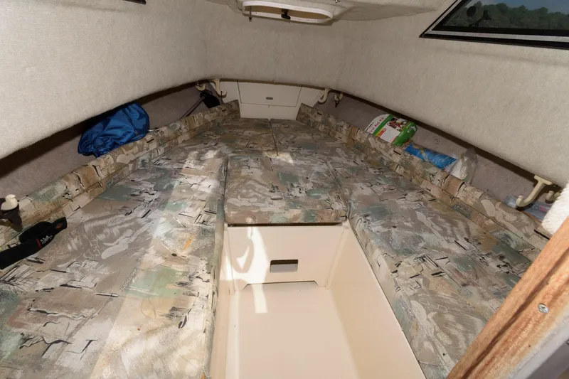 Slide: The Image of 1994 Grady-White Adventure 208 cabin interior with patterned cushions and storage space. - 12