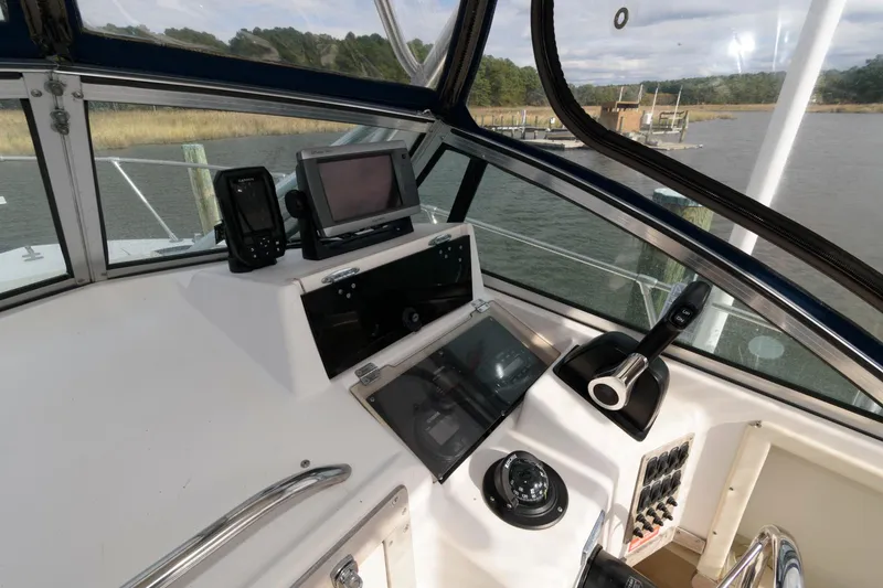 Slide: The Image of 1994 Grady-White Adventure 208 boat cockpit with navigation equipment and steering wheel. - 6