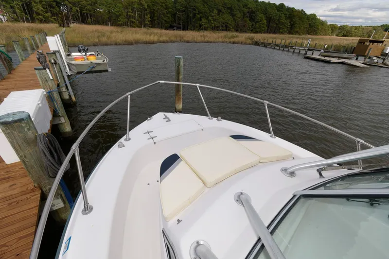Slide: The Image of 1994 Grady-White Adventure 208 boat docked by a serene lake with lush greenery. - 8
