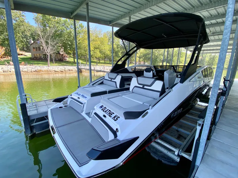 Slide: The Image of 2019 Yamaha Boats 275 SE docked under a covered marina, featuring sleek design and spacious seating. - 14