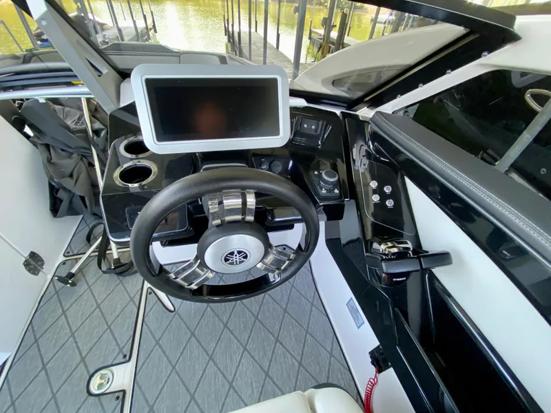 Slide: The Image of 2019 Yamaha Boats 275 SE cockpit with steering wheel and touchscreen display. - 23