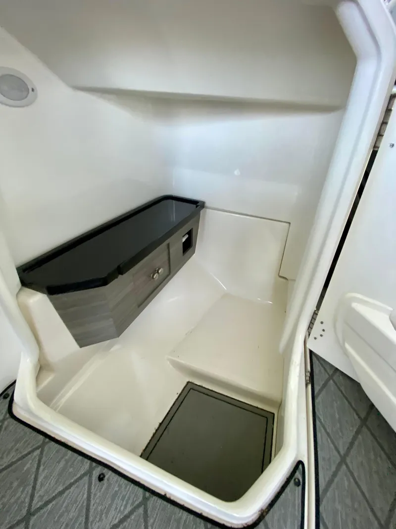 Slide: The Image of 2019 Yamaha Boats 275 SE interior cabin with storage and seating. - 27