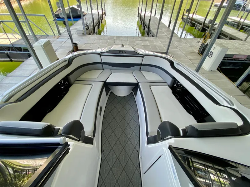Slide: The Image of 2019 Yamaha Boats 275 SE interior with spacious seating at a dock. - 31