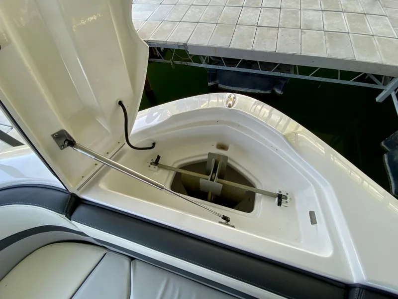 Slide: The Image of 2019 Yamaha Boats 275 SE anchor storage compartment, open lid, white interior. - 34
