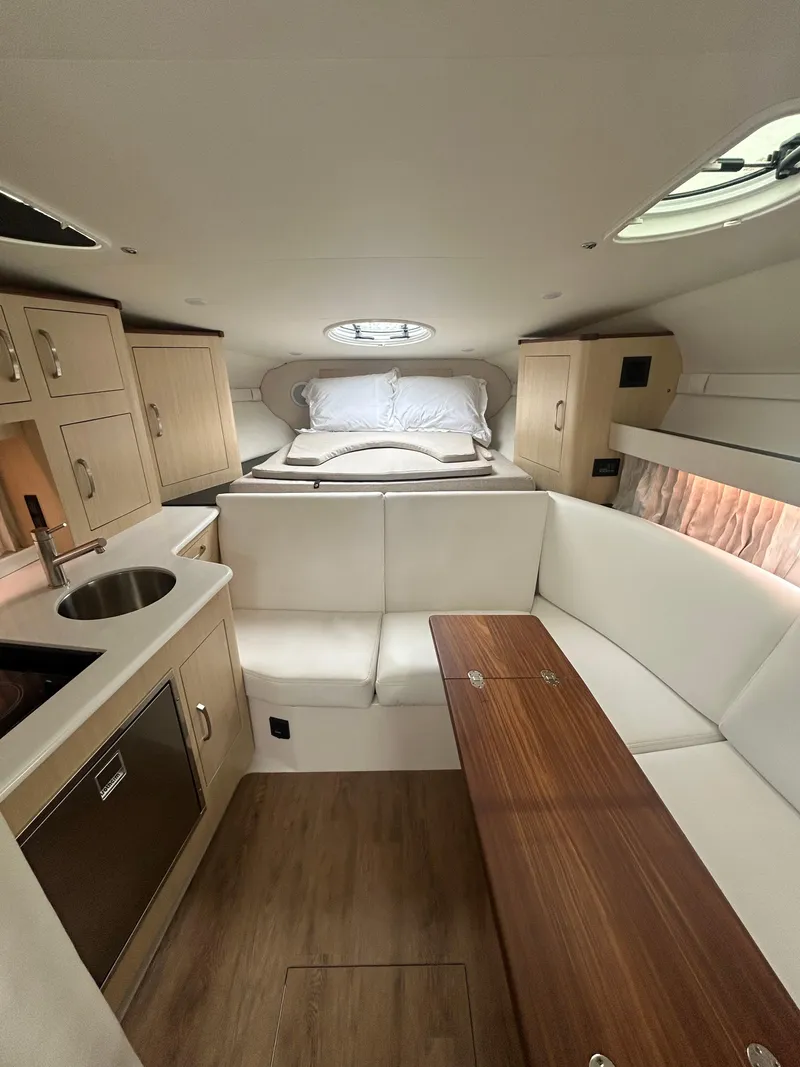 Slide: The Image of 2024 Regal 33 XO cabin interior with kitchenette, seating, and bed. - 11