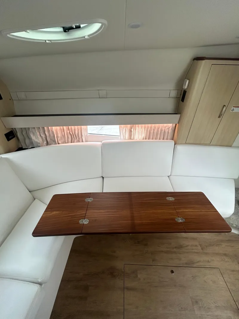 Slide: The Image of 2024 Regal 33 XO interior with white seating and wooden table. - 12